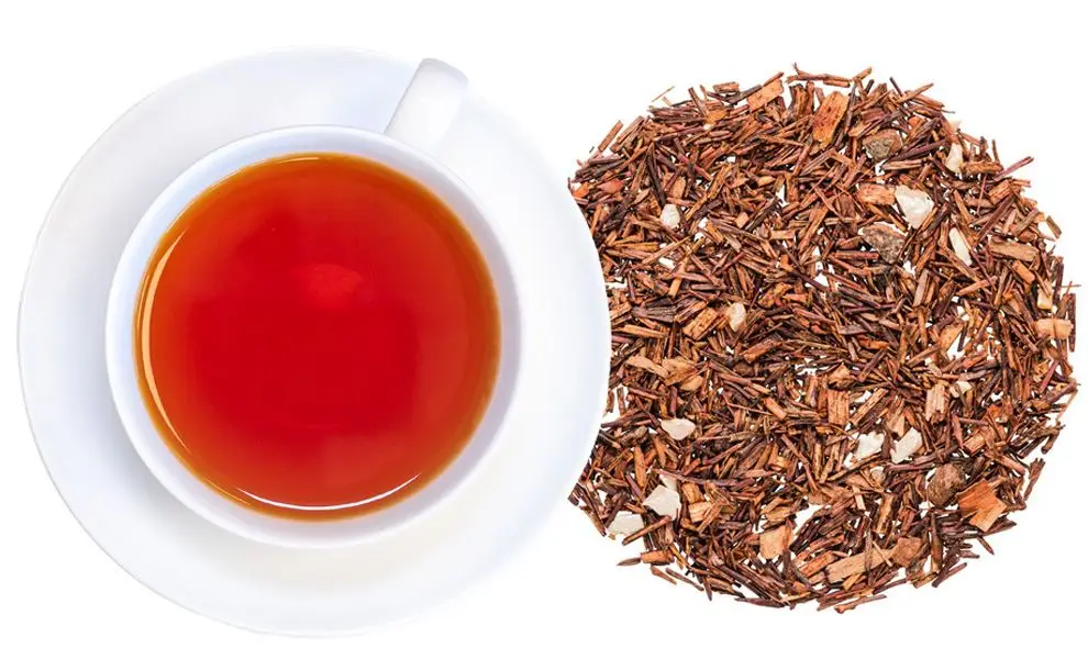 Organic Apricot and Peach Honeybush herbal tea with peaches, apricots, and rose petals in a cozy tea setting