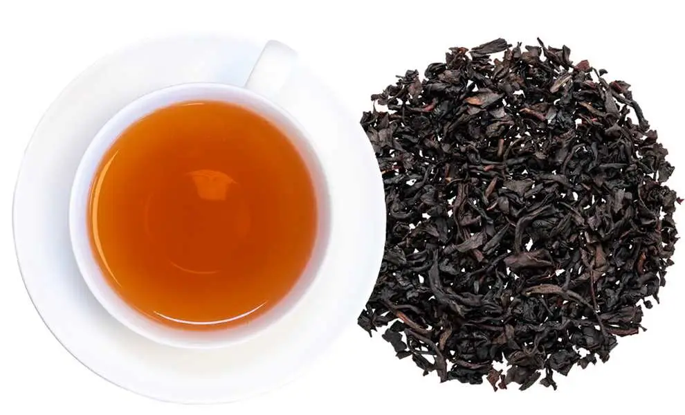 Organic Vanilla Black Tea with loose black tea leaves, vanilla beans, and a freshly brewed cup of aromatic tea